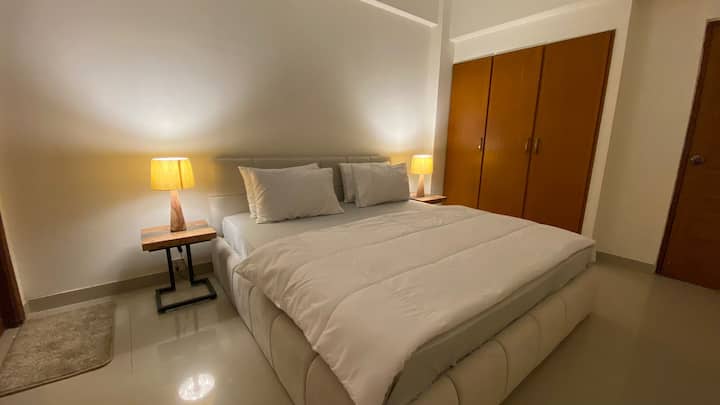 Notre chambre offre une escapade tranquille avec un lit queen size, baigné de lumière naturelle pendant la journée et une lampe confortable le soir.