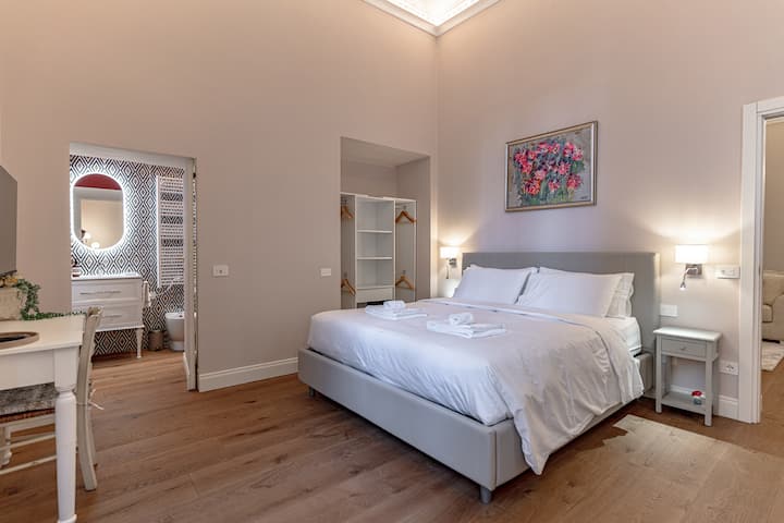 Главна спалня с голямо двойно легло, оригинална стенна картина, самостоятелна баня и възможност за добавяне на единично легло или бебешко креватче
