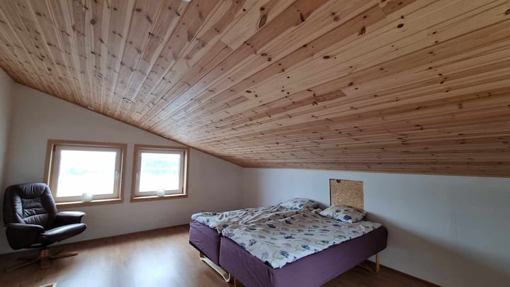Loft spacieux avec deux lits de 90 lits, table de chevet (non illustrée), fauteuil et canapé de cuisine