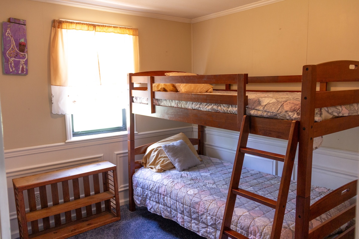 Ეს არის საბავშვო ზომის ოთახი ორსართულიანი საწოლებითა და კარადათი. ახალი ხალიჩა. 