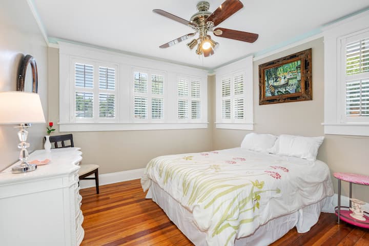 Descubre la comodidad y el encanto en el acogedor segundo dormitorio, que cuenta con una acogedora cama tamaño queen con ropa de cama elegante, almohadas cómodas y ventilador de techo.