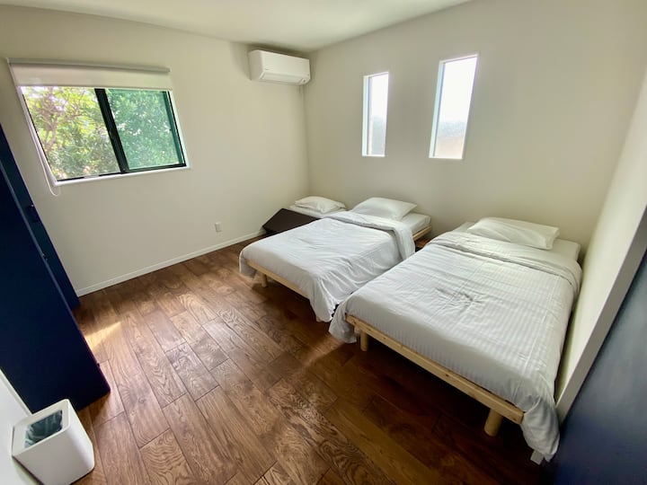 無垢材のやさしい香りに包まれる、落ち着いたツインルーム。隣室とは防音壁で区切られており、プライベートも安心です。自然光がたっぷり入り、朝の目覚めも爽やか。全体でシングルベッド4台＋敷布団対応可。

