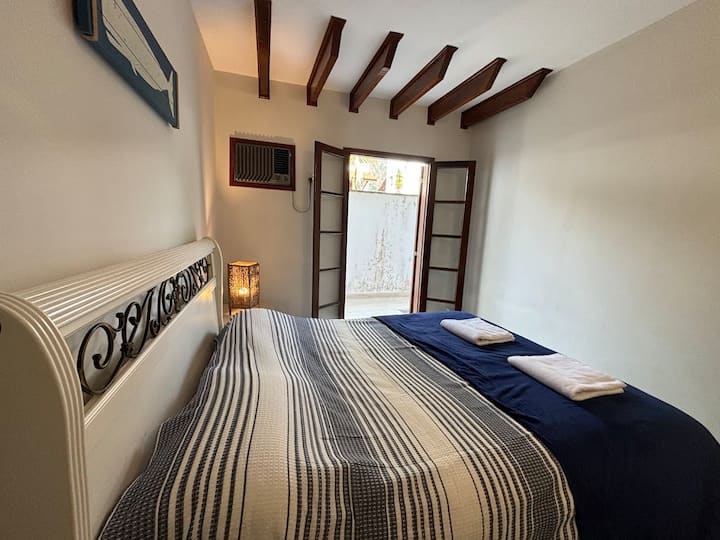 Quarto com cama de casal e ar condicionado.