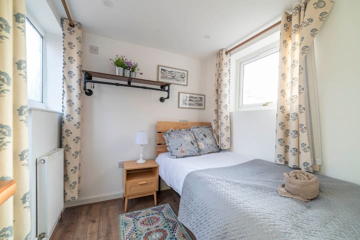 Creando un ambiente tranquilo para una gran noche de sueño, el dormitorio individual de la planta baja cuenta con una decoración relajante, iluminación suave y ropa de cama acogedora, lo que garantiza comodidad y relajación para un descanso tranquilo.