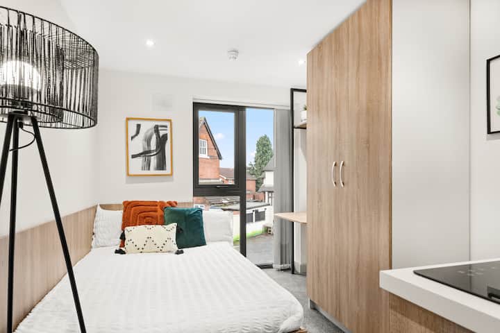 Acogedora cama doble vestida con sábanas frescas y frescas, lo que garantiza un sueño nocturno reparador y rejuvenecedor.