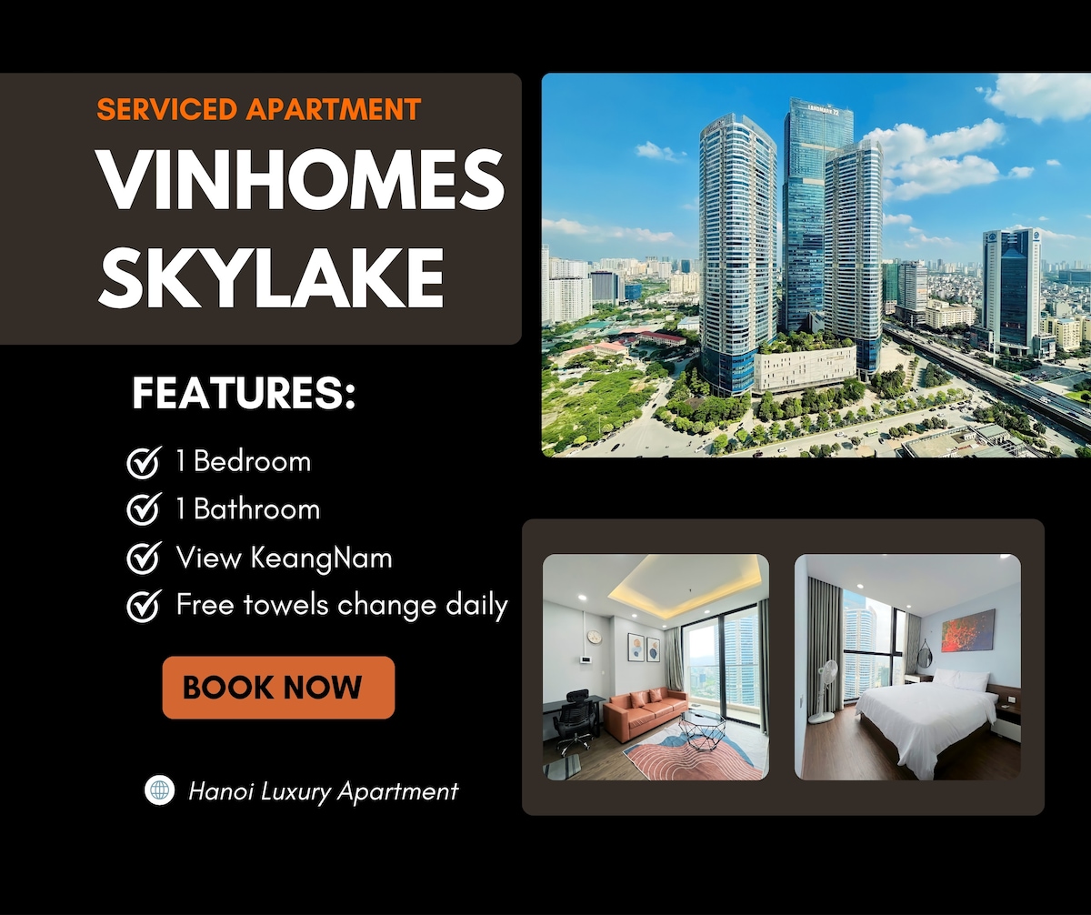 A contemporary serviced apartment is showcased, featuring a spacious bedroom, a modern bathroom, and a well-furnished living area. The view includes the iconic KeangNam building, with the urban skyline visible through floor-to-ceiling windows. Comfortable seating arrangements are seen in the living space.