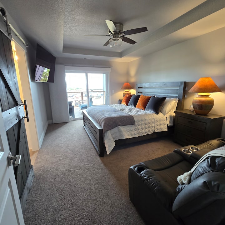 Dormitorio principal con baño privado con cama tamaño king, un sofá cama reclinable de cuero. Increíble vista del puerto deportivo, el embarcadero y el río Columbia.