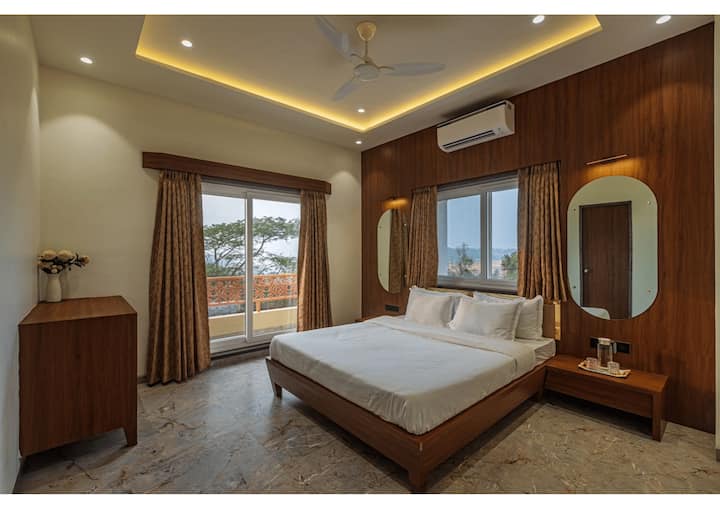 Kjo dhomë gjumi me ajër të kondicionuar ka shtroja të buta, dekor elegant, dritare të mëdha me perde të mëdha dhe një ballkon privat, duke krijuar një atmosferë të qetë dhe ftuese të mbushur me dritë natyrale.