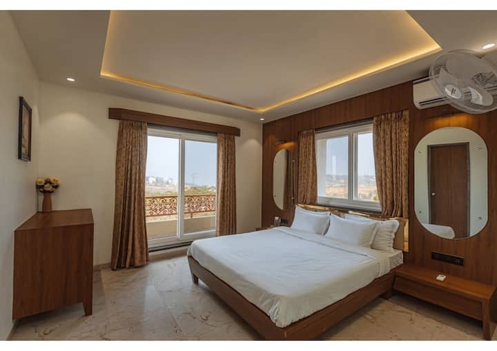 Kjo dhomë gjumi me ajër të kondicionuar ka shtroja të buta, dekor elegant, dritare të mëdha me perde të mëdha dhe një ballkon privat, duke krijuar një atmosferë të qetë dhe ftuese të mbushur me dritë natyrale.