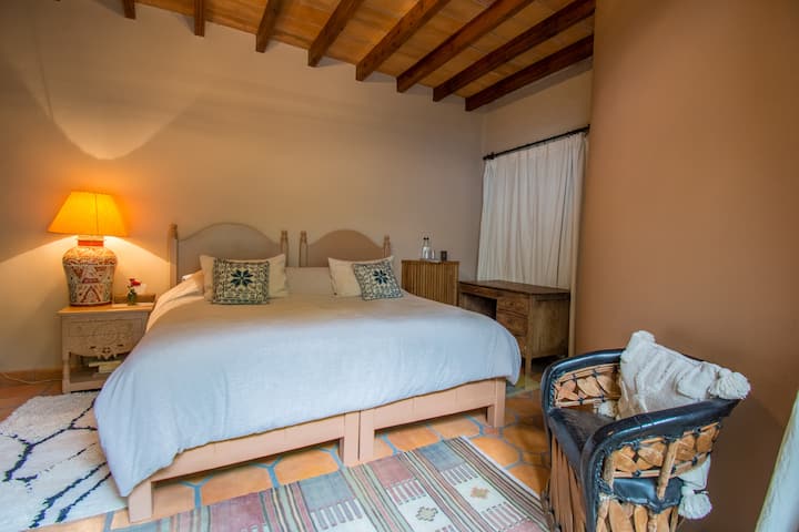 Рекамара бр. 4 приземје со брачен кревет и поглед кон градината, тавански вентилатор. Заедничка  бања  со спална соба бр. 3