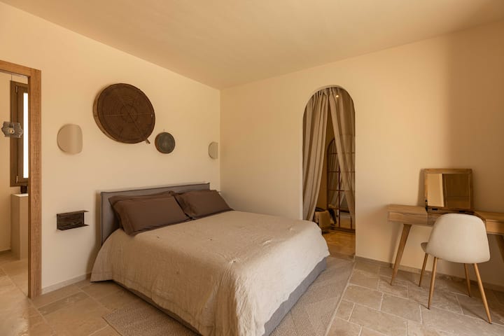 Una camera matrimoniale con bagno privato e cabina armadio offre una disposizione spaziosa, studiata con cura per il comfort e la funzionalità, con accesso diretto alla piscina.