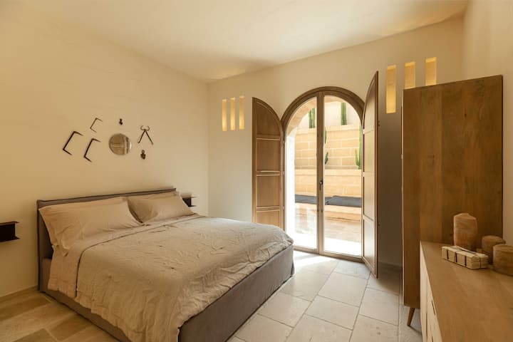 La camera da letto matrimoniale con bagno in camera include un grande letto, comodi posti a sedere e arredi eleganti.