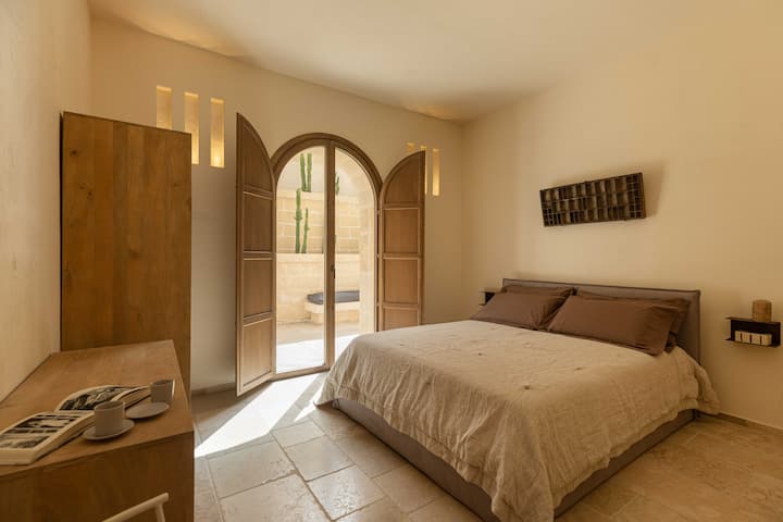 Una camera da letto matrimoniale con bagno in camera include un grande letto, posti a sedere e arredi eleganti.