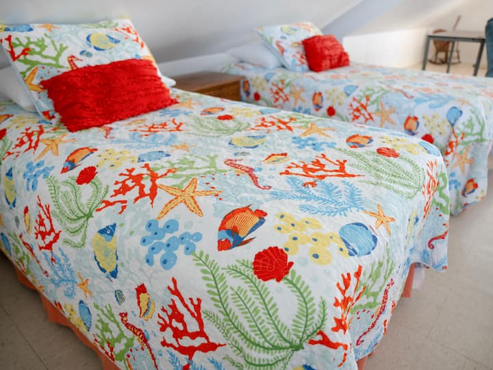 พักผ่อนอย่างสบายบนเตียงสไตล์ทรอปิคอลชั้นบน ซึ่งได้รับการออกแบบมาเพื่อการนอนหลับที่เงียบสงบและช่วยฟื้นฟูพลัง