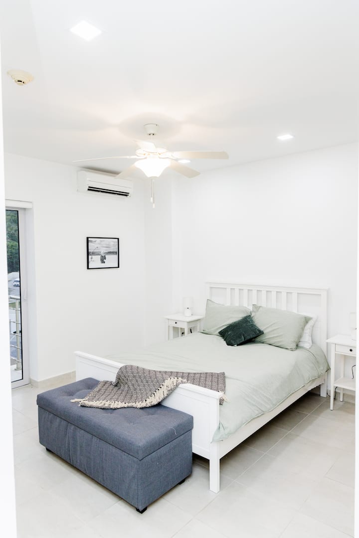 Bedroom 3 features a queen sized bed, storage sortage chest, A/C,  and balcony access.