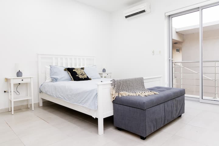 Bedroom 2 features a queen sized bed, storage sortage chest, A/C,  and balcony access.
