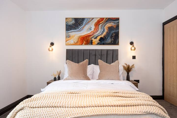 დიდი ორადგილიანი საძინებელი თანამედროვე დეკორით, მყუდრო თეთრეულითა და ბუნებრივი სინათლით