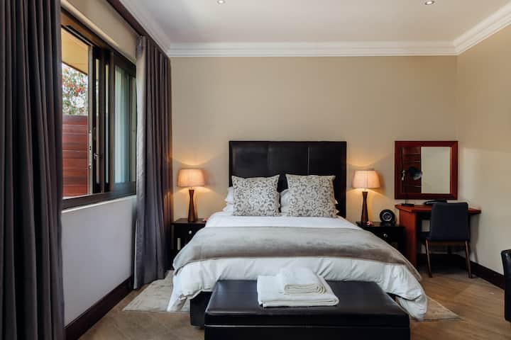 Cama tamaño queen con mantas adicionales y ropa de cama de calidad con baño privado, ducha, lavabo e inodoro. Toalleros con calefacción y toallas blancas suaves. Caja fuerte incorporada dentro de un armario grande. Puerta exterior que se abre a la gran zona de patio trasero amueblado.