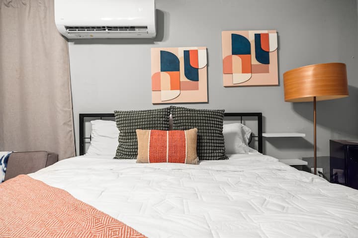 מיטת קינג סייז עם טלוויזיה, פוטון, מקרר ופינת קפה בחדר השינה שלכם.