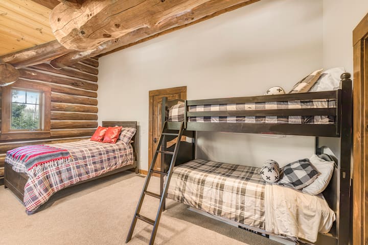 Questa accogliente camera a castello è perfetta per i bambini o per gli ospiti extra, con un letto a castello a due letti, un letto a due letti separato, biancheria da letto a quadri giocosa e il fascino rustico di una baita in legno. Uno spazio divertente e confortevole per riposare e sognare avventure.