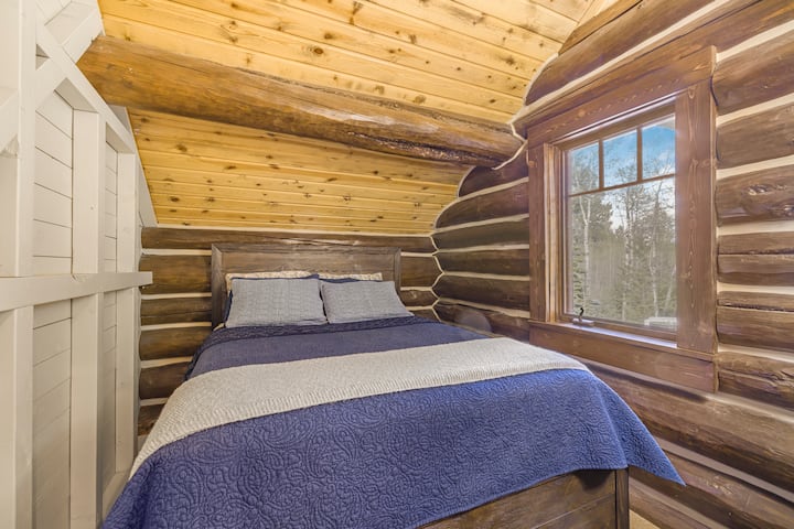 Nascosta sotto un accogliente soffitto spiovente, questa affascinante camera da letto in legno presenta un letto morbido, calde pareti in legno e una tranquilla vista sulla foresta circostante, un rifugio intimo e riposante perfetto per notti tranquille e mattine in montagna.