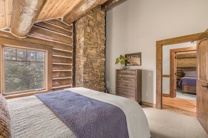 Questa accogliente camera da letto combina l'eleganza rustica con il comfort moderno, con un letto accogliente, una colonna in pietra naturale e dettagli in legno. La luce soffusa che filtra dalla finestra e le calde finiture in legno creano uno spazio tranquillo dove riposarsi e ricaricarsi.