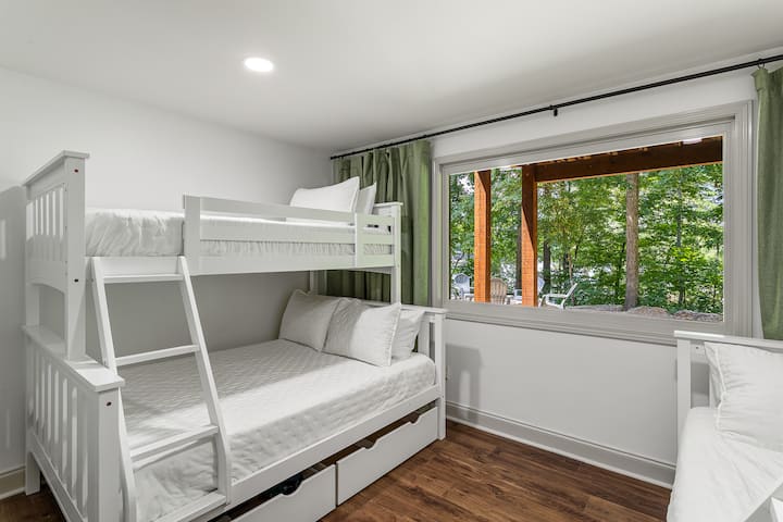 Უჯრები განთავსებულია თითოეული სრული საწოლის ქვეშ შესანახად. Ოთახში არის შავი ფარდები და თეთრი ხმაურის აპარატი.