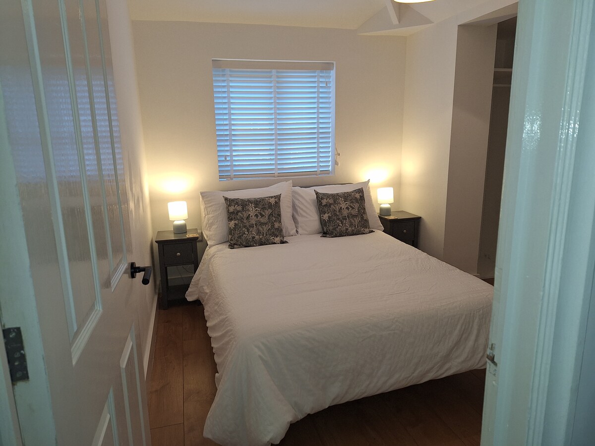 Este es el dormitorio principal, con baño privado. Es una cómoda cama doble, con luces laterales.
También hay un tocador/mesa de trabajo y una silla. Hay un armario con perchas.