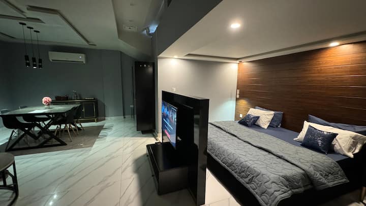 Shijo më të mirën e të dyja botëve. Tavolina e televizorit shërben si një ndarës elegant dhe funksional në apartamentin tonë në studio, duke ruajtur privatësinë