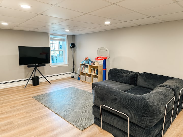 تلفزيون وغرفة ألعاب مع أريكة نوم كبيرة