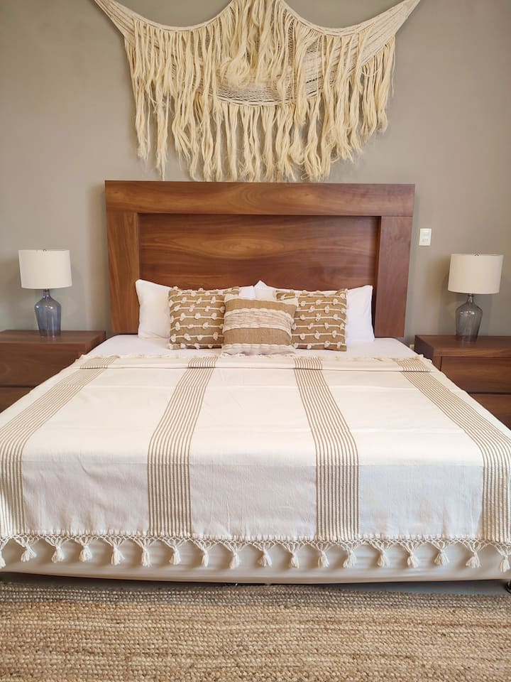 Chambre principale avec lit King Size, salle de bain entière attenante. Draps, serviettes, Wi-Fi, télévision connectée, couvertures, placard, cintres, coffre-fort, climatisation et ventilateur de plafond.