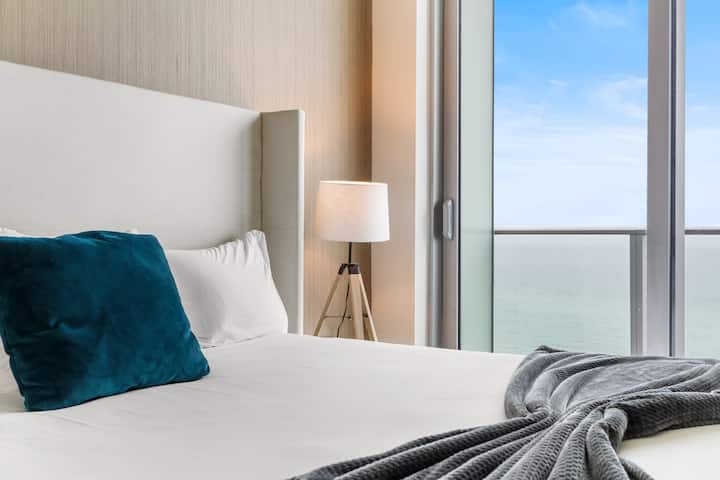 Step into the bedroom, where a plush king-size bed invites restful nights and floor-to-ceiling windows open to calming ocean views.
