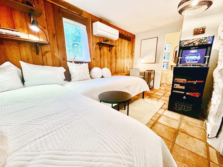 Dy krevate dopio prej pelushi. Njësia e lojërave Vintage Asteroids Delux arcade. Hapësirë e dedikuar pune. Dollap shëtitës.