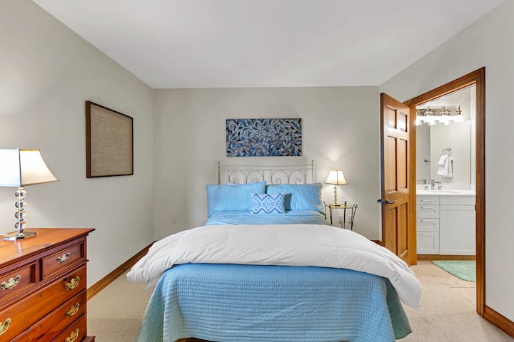 The secondary bedroom has a large closet, cozy linens and a gorgeous newly remodeled en suite bathroom. 
