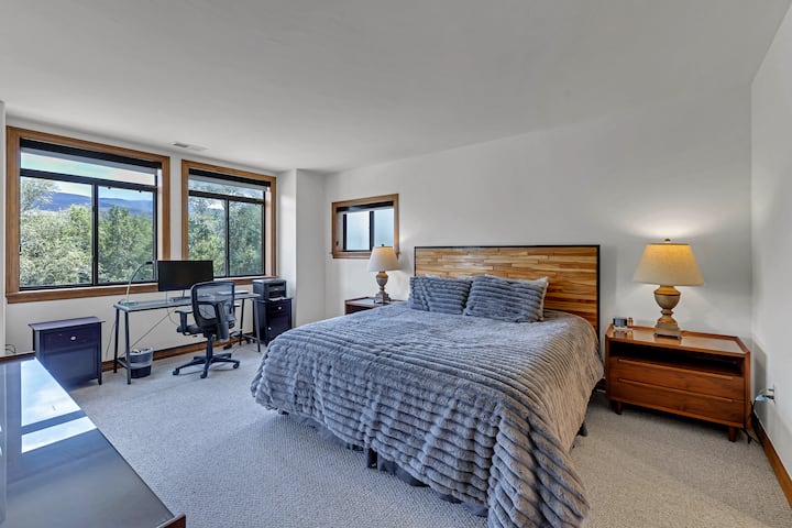 The oversized primary bedroom has river views,  TV, work station, newly updated en suite bathroom and a lush comforter that you will love wrapping around you after a snowy day outside. 