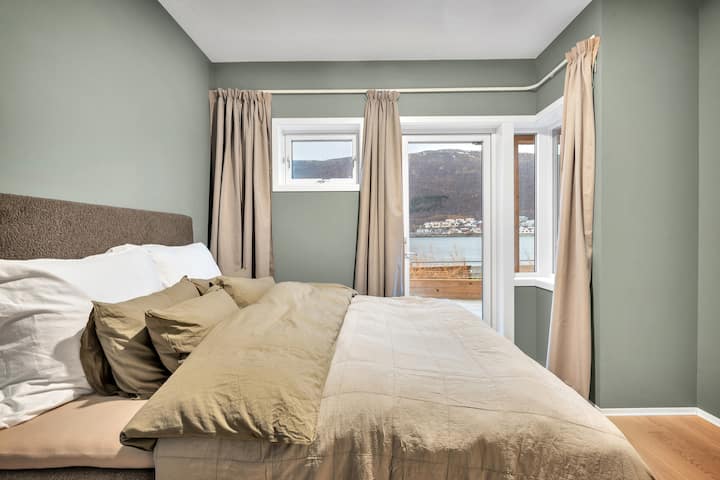 The main bedroom features a luxurious and large bed by Norwegian bed maker, Wonderland, and fluffy goose down pillows and comforters. It also features blackout curtains, clothing storage, and a direct entrance to the front porch.