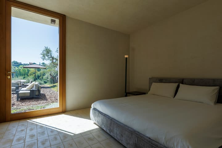 Suite 5 - Oasis ya uzuri, ambapo mlango wa Kifaransa unafunguka moja kwa moja kwenye ua na bwawa, ukizama chumba katika mwanga wa asili na kuunda mazingira ya mapumziko yaliyosafishwa.
