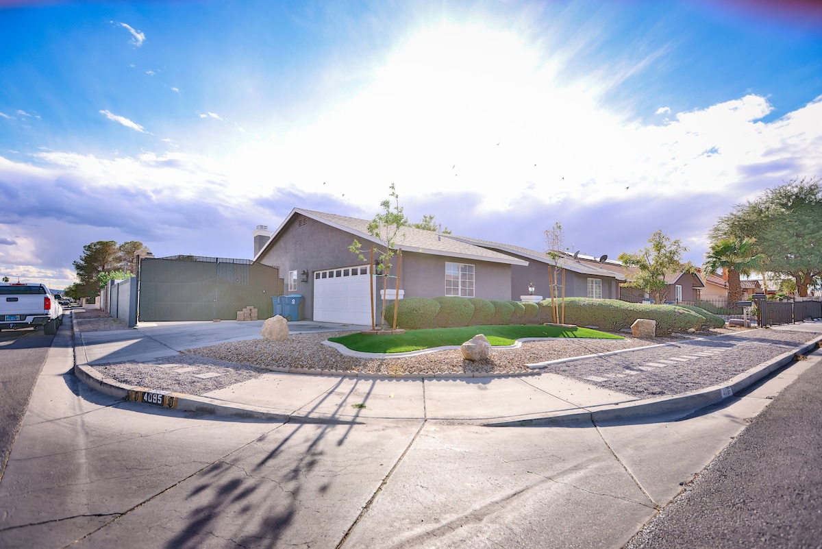 The exterior of the corner lot home is showcased with ample landscaping, providing a clean and spacious appearance. Large windows reflect sunlight, and the inviting driveway offers parking options. The property is surrounded by a modest fence, enhancing privacy and tranquility.