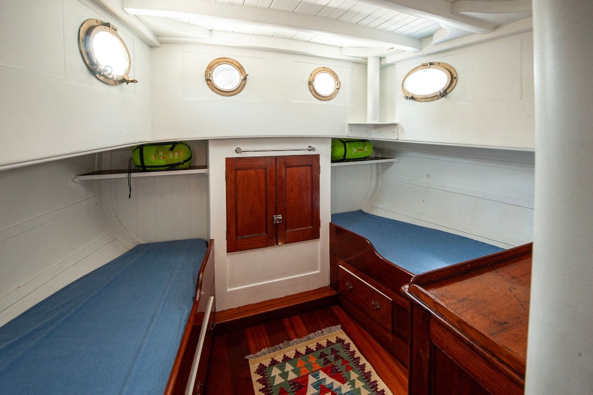 La cabina N°2 situada en la parte trasera del barco ofrece dos camas individuales con colchones muy cómodos. Diferentes muebles y espacios de almacenamiento permiten guardar sus pertenencias personales durante su estadía.