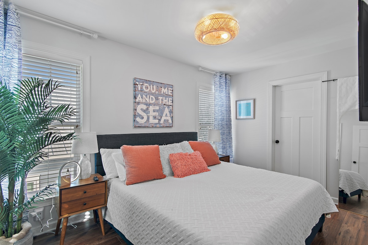 The primary bedroom includes bed, bedside tables, ceiling fan, alarm clock, white noise machine, walk-in closet, full-length mirror and TV. The closet features built-ins to store clothing, extra bedding and light yoga equipment. 