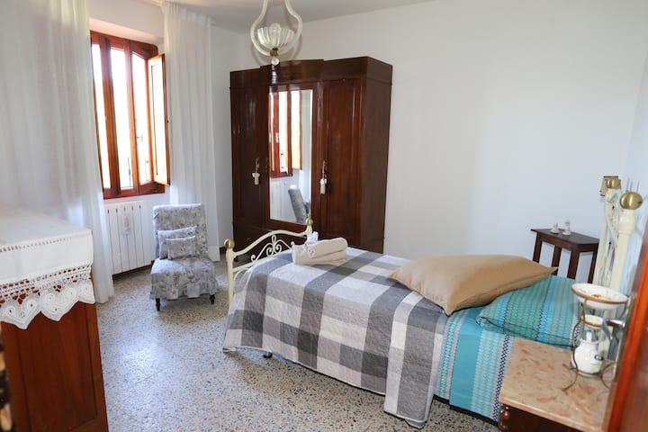 Jednolôžková spálňa so súpravou uterákov a súpravou na zdvorilosť.