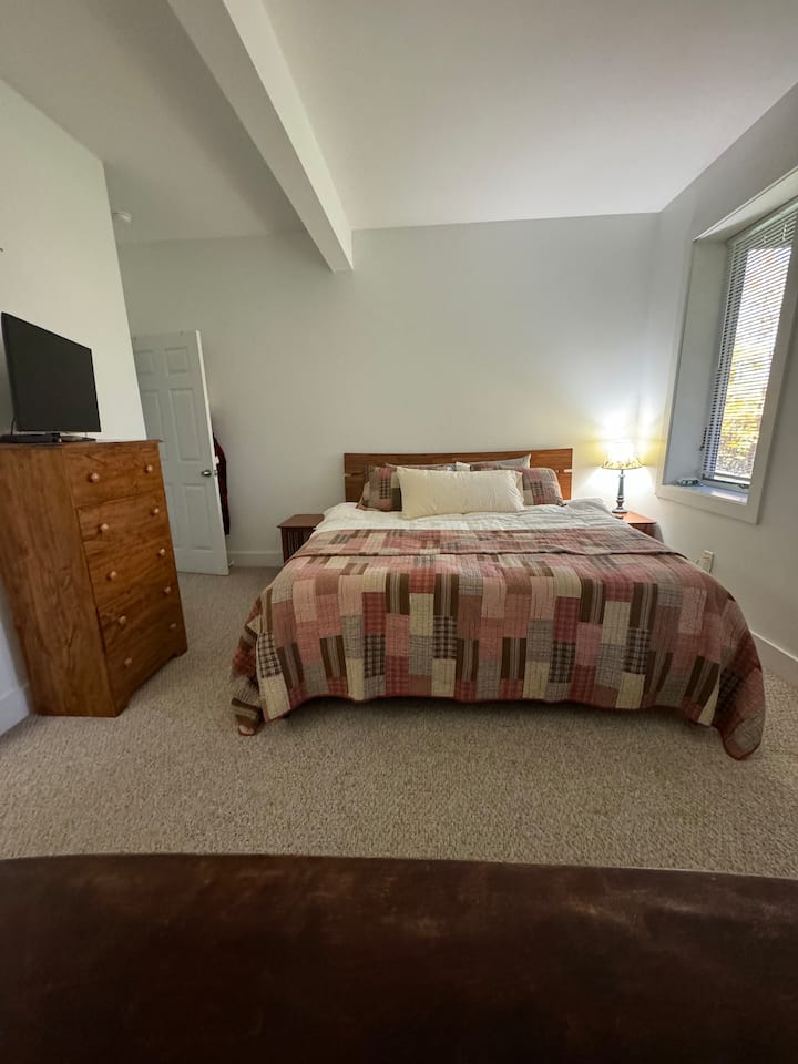 Toto je spálňa s manželskou posteľou King na spodnom poschodí domu, ktorá má tiež plnú kúpeľňu, w/d, obývaciu a kuchynskú časť s prístupom na dvor.