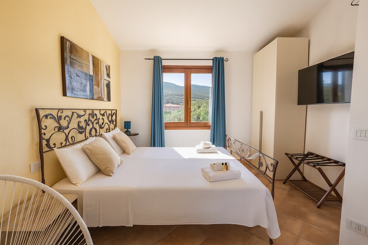 Angenehmes Zimmer zu jeder Jahreszeit: hell im Sommer, frisch im Frühling und einladend im Herbst. Komfortables Bett, gepflegte Einrichtung und großes Fenster mit Blick auf die Hügel.