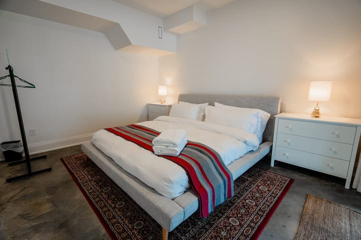 King sized bed in the basement in walk-out basement with its own dedicated patio doors.