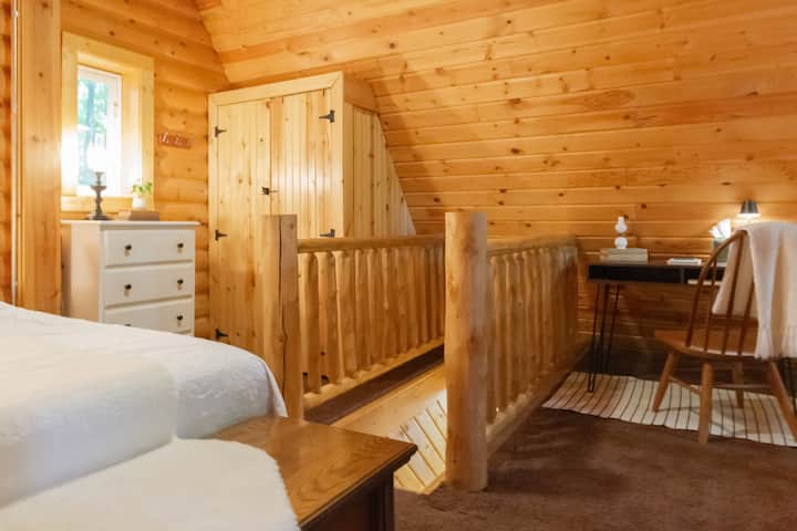 The upstairs bedroom includes a queen size bed, closet, dresser, lounge chair, and desk/chair. Additional blankets are in the trunk at the base of the bed.