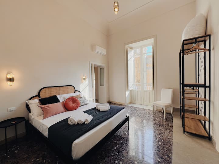 سرير رئيسي كبير مشرق مع إمكانية الوصول إلى حمام كبير مع حوض استحمام ودش