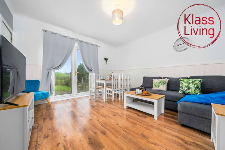 พื้นที่นั่งเล่นและพื้นที่รับประทานอาหารแบบเปิดโล่งกว้างขวางที่ Klass Living Short Lets & Serviced Accommodation Airdrie มีประตูระเบียง แสงธรรมชาติสว่างมาก และการตกแต่งที่มีสไตล์