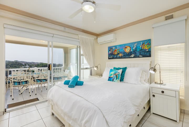 Laguna La Crete 73 - Das Hauptschlafzimmer verfügt über eine Klimaanlage. Wache mit atemberaubendem Meerblick auf und verbringe deine Tage damit, die magischen Sonnenuntergänge vom geräumigen Balkon aus zu bestaunen. Er ist auch perfekt, um deinen Morgenkaffee mit dem beruhigenden Rauschen der Wellen zu genießen.