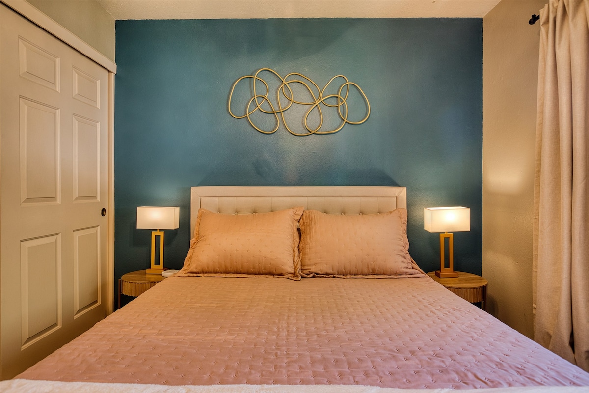 El luminoso y colorido dormitorio queen incluye colcha suave, manta, almohadas, mesita de noche, lámparas, estación de carga y cortinas opacas