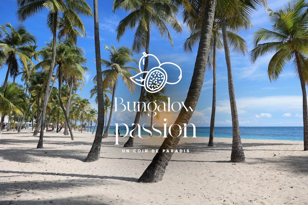 A serene beach scene is framed by tall palm trees, casting shadows on the soft sand. The calm azure sea meets a clear sky, inviting relaxation and exploration. The tranquil atmosphere suggests an ideal escape in a picturesque coastal setting.